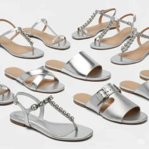 Detailed view of the delicate T-strap design on a pair of silver flat sandals, showcasing their intricate craftsmanship.